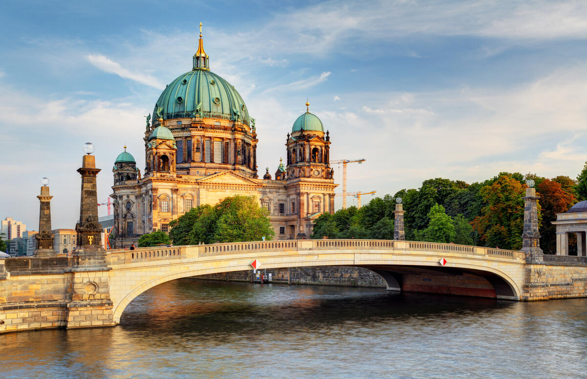 Friedrichsbrücke in front of Berlin Cathedral, its facade lit by the low sun.