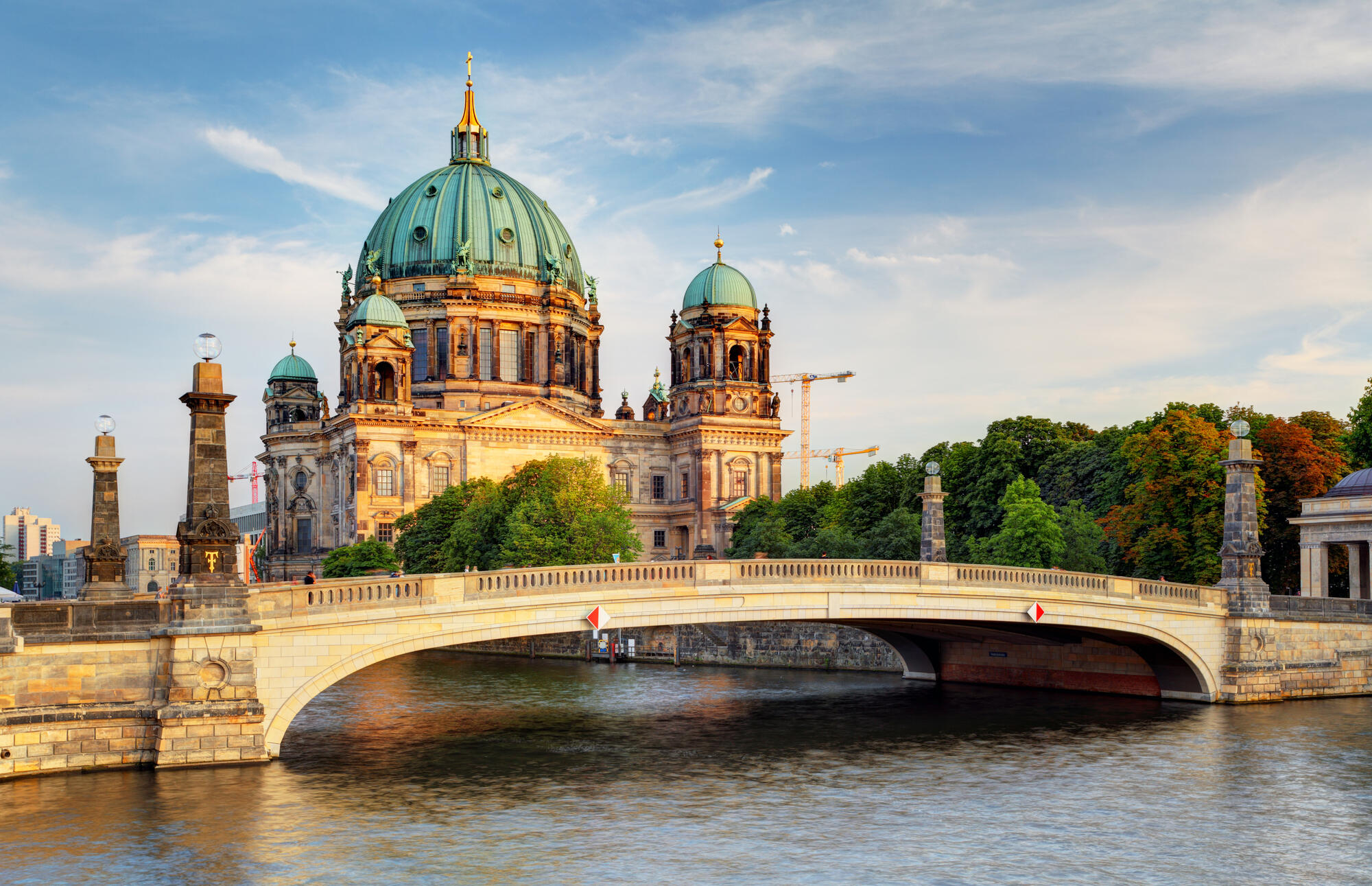 Friedrichsbrücke in front of Berlin Cathedral, its facade lit by the low sun.