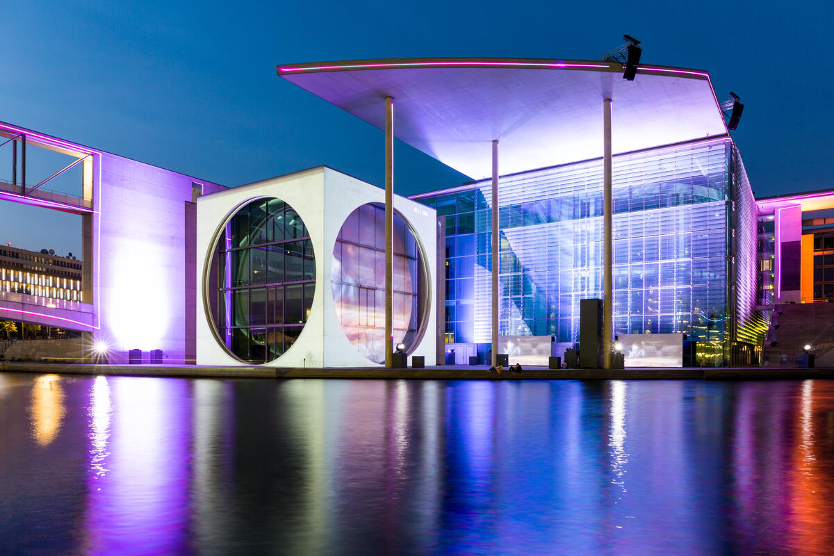 Marie-Elisabeth-Lüders-Haus by the Spree, with a blue and violet illuminated glass facade and large circular window.