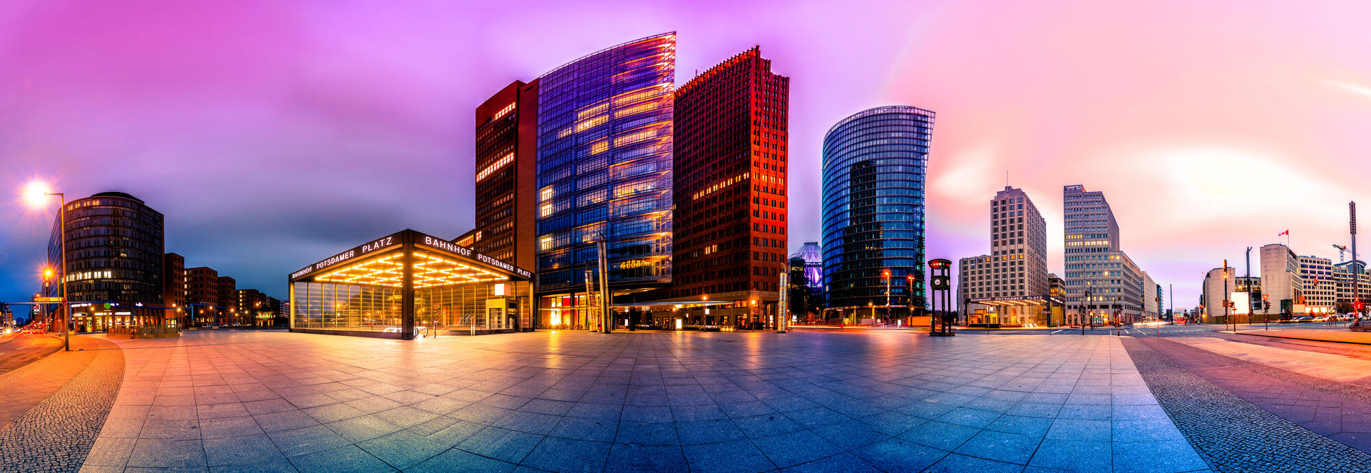 An artistically processed panoramic montage of Potsdamer Platz, with a pink evening sky and glass towers.