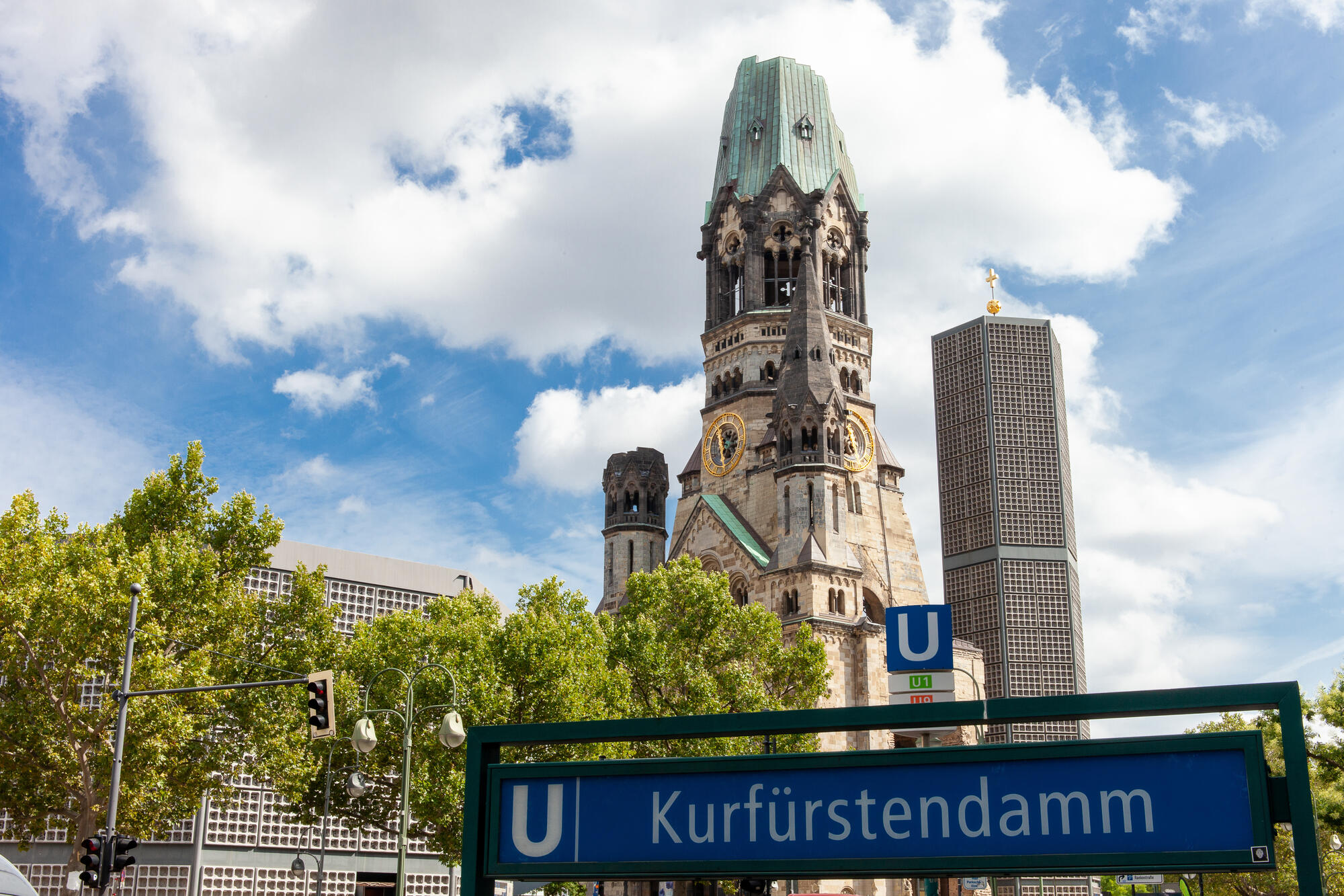 The old and new towers of Kaiser Wilhelm Memorial Church behind the Kurfürstendamm U-Bahn entrance.
