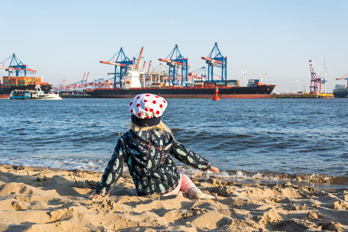 A child wearing a sun hat on an Elbe beach.