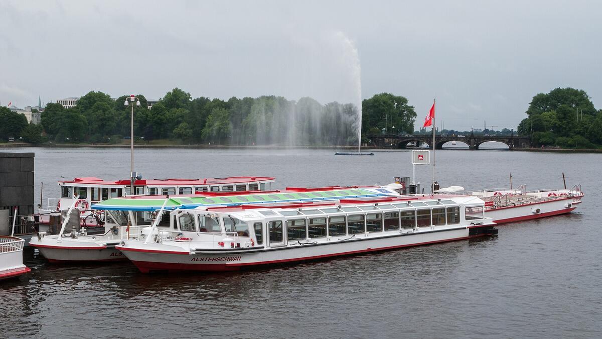 Landing stages and boats on Hamburg’s Binnenalster beneath a cloudy sky.