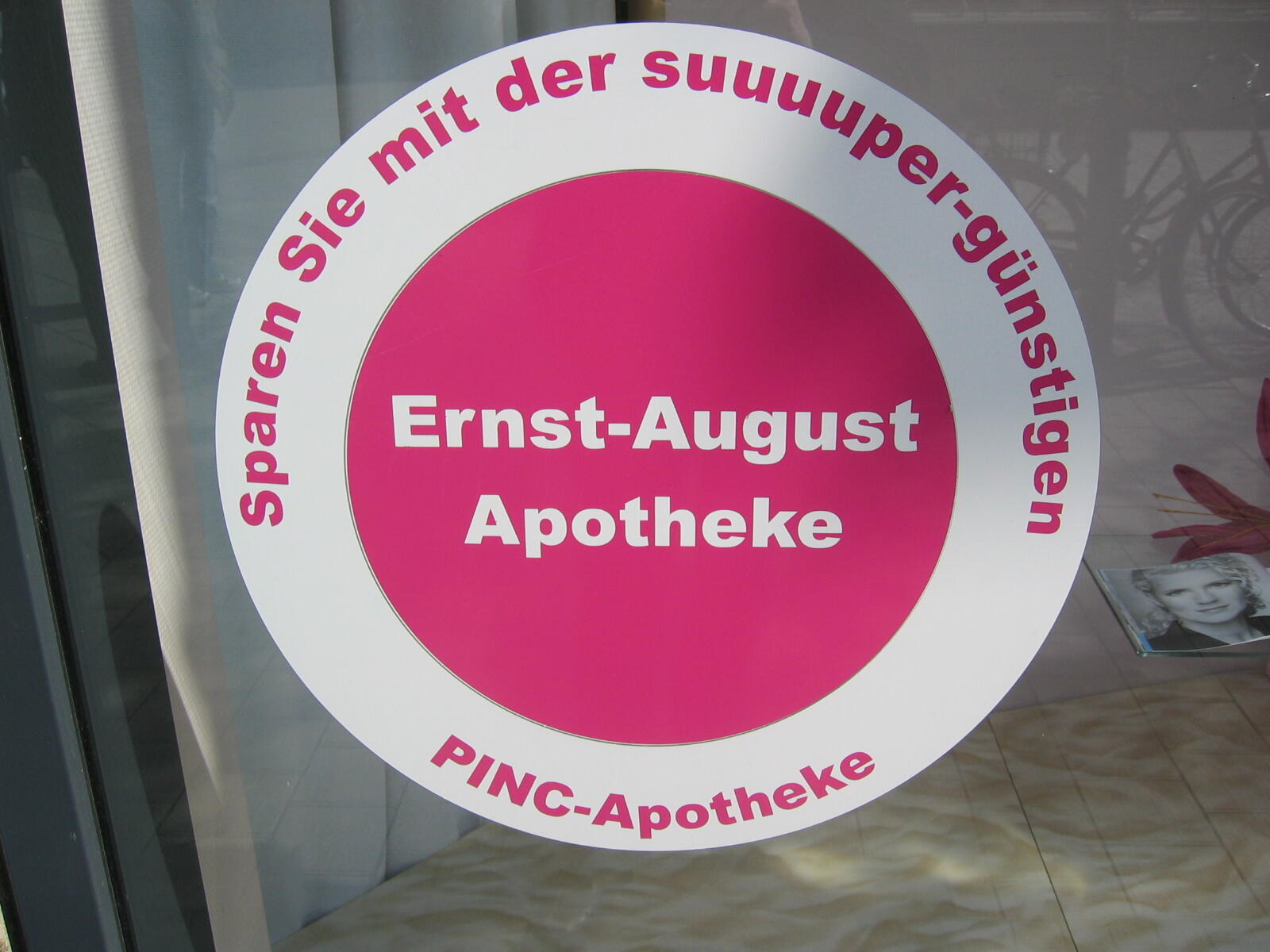Pink Ernst-August-Apotheke stickers in a shop window