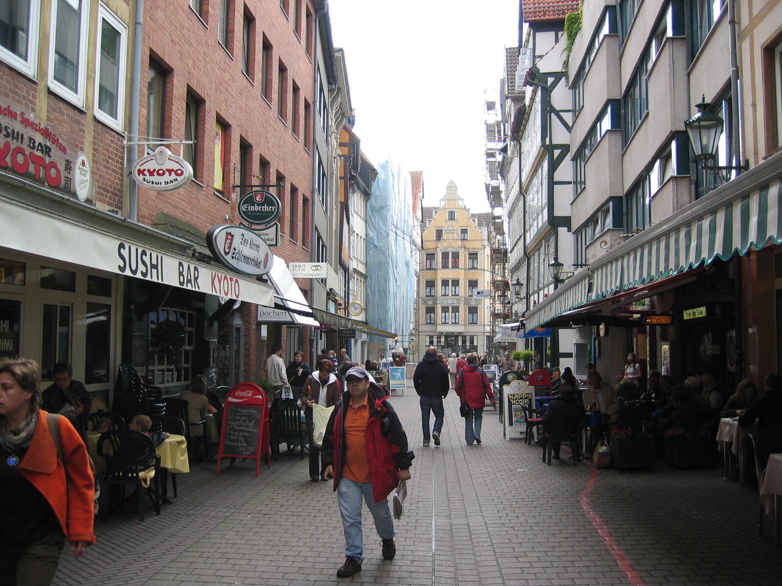 Bustling lane in the old town with a sushi bar and pavement cafés