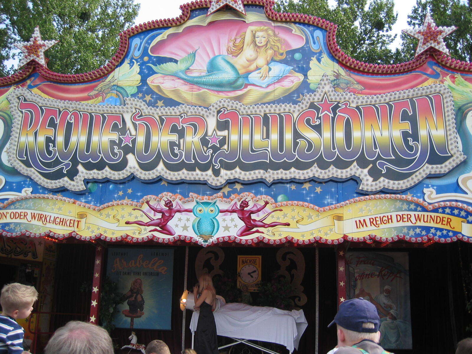 Colourfully painted fairground booth ‘Revue of Illusions’
