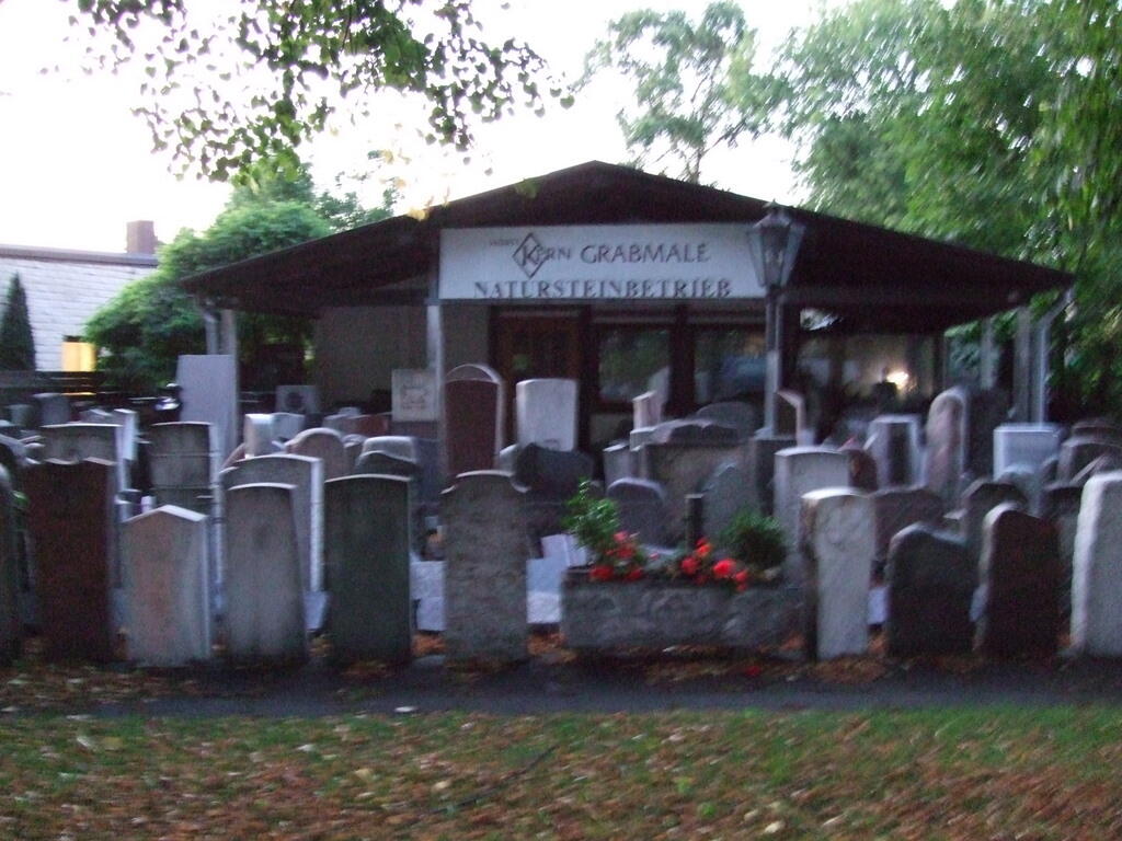 Gravestones on display at a stonemason’s at dusk