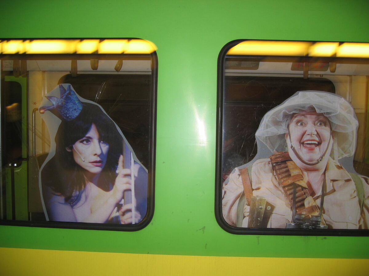 Green light rail carriage with window advertising