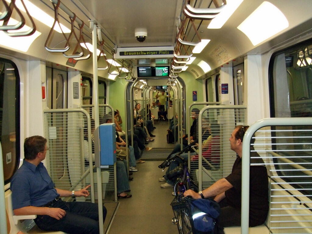 Interior of a light rail carriage with seated passengers