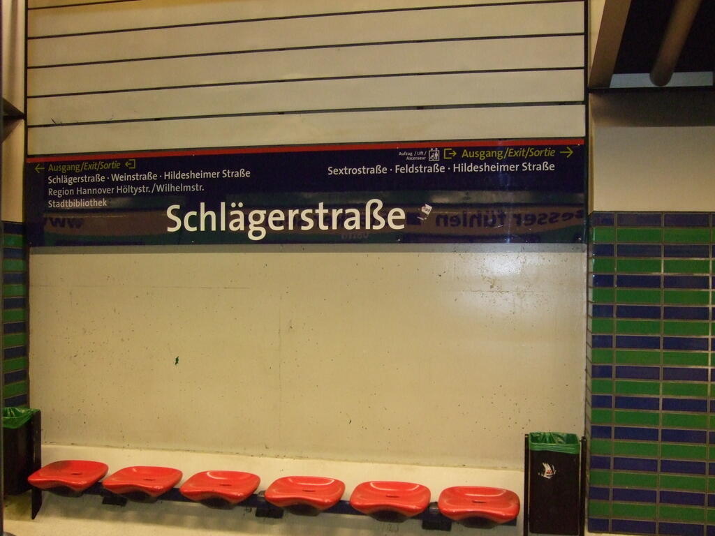 Schlägerstraße station sign with red seats at the light rail station