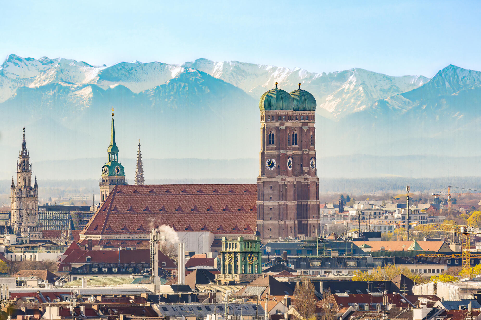 Munich’s Frauenkirche against an Alpine panorama.