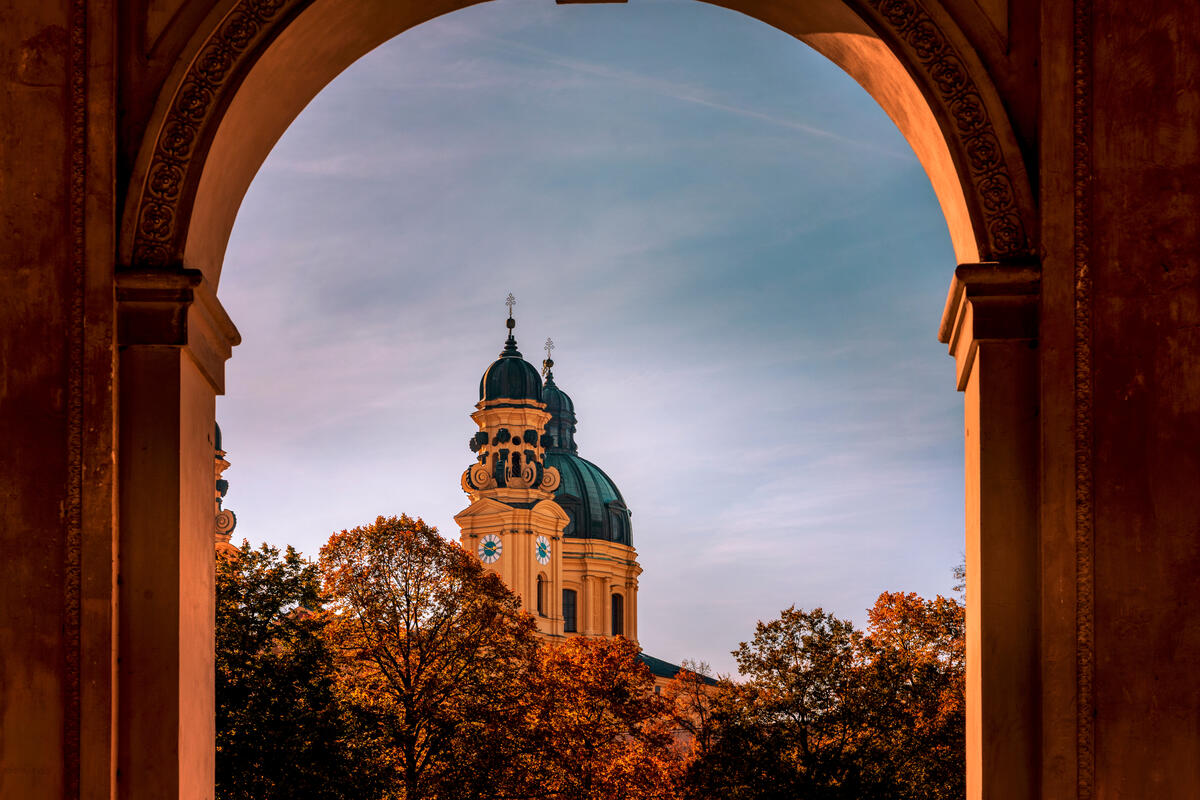 Theatinerkirche framed by an arch in the Hofgarten.