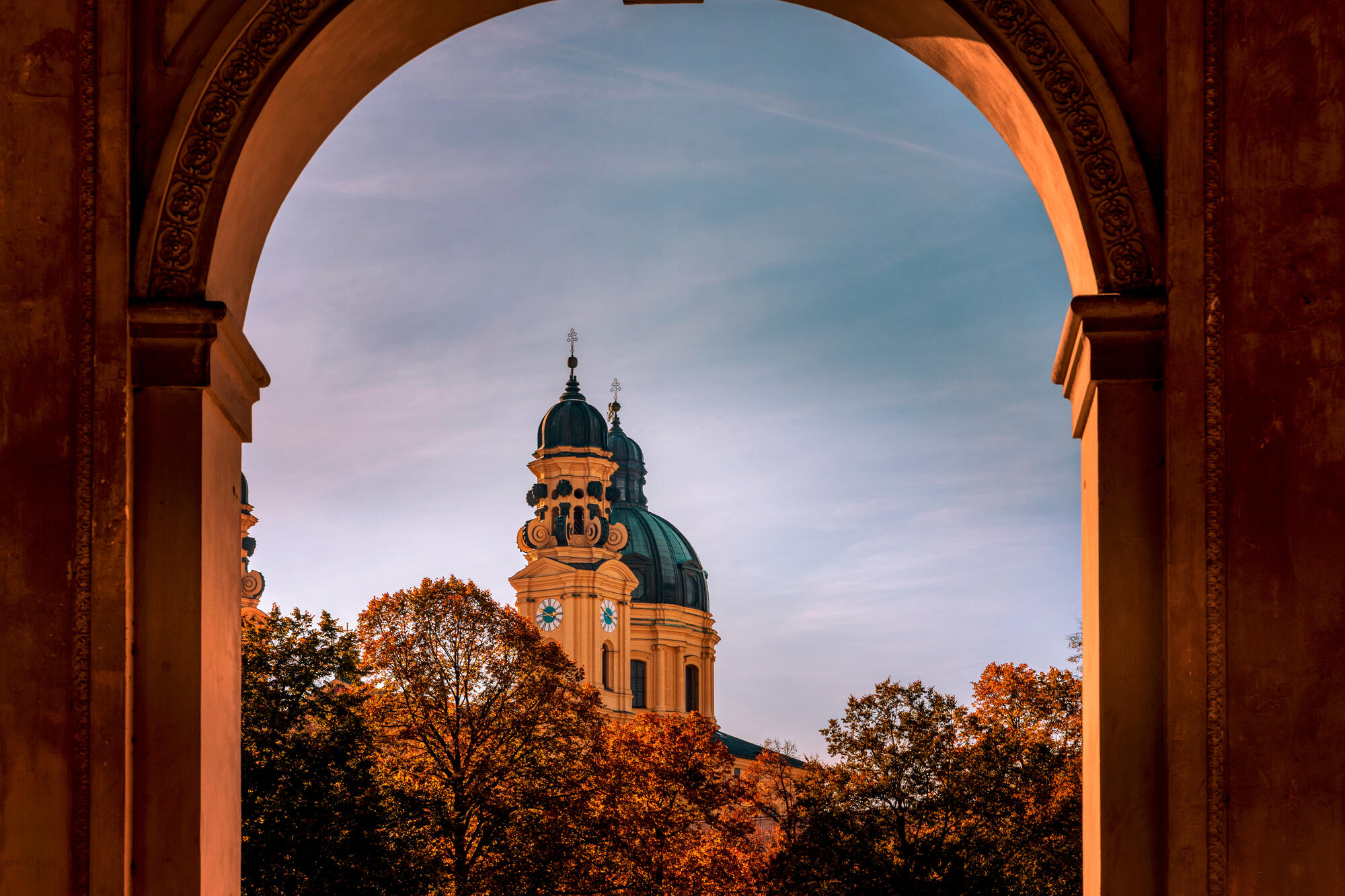 Theatinerkirche framed by an arch in the Hofgarten.