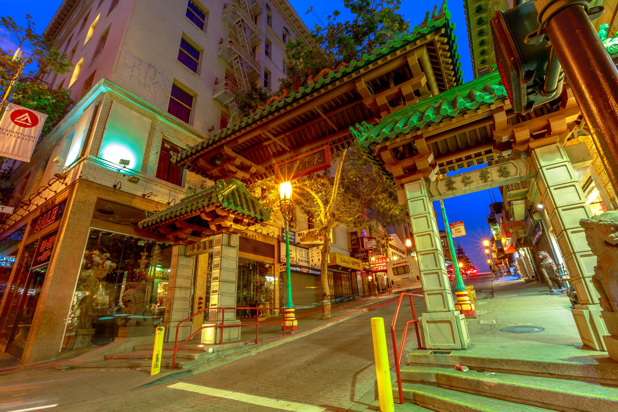 Chinatown's illuminated gate, with green roofs and decorated supports, spans the street entrance.