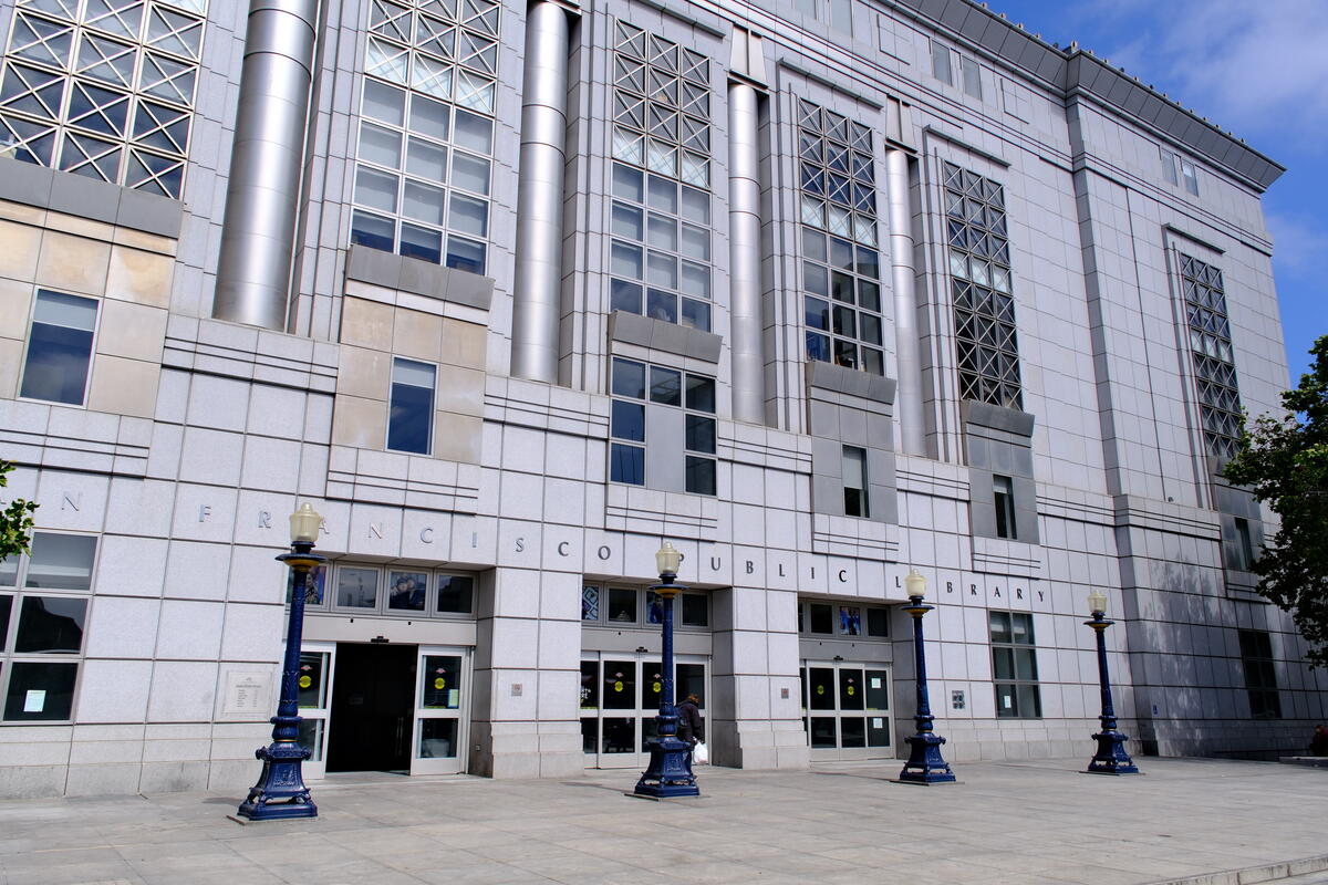 Broad steps lead to the library doors beneath tall window bays with geometric metal grilles.