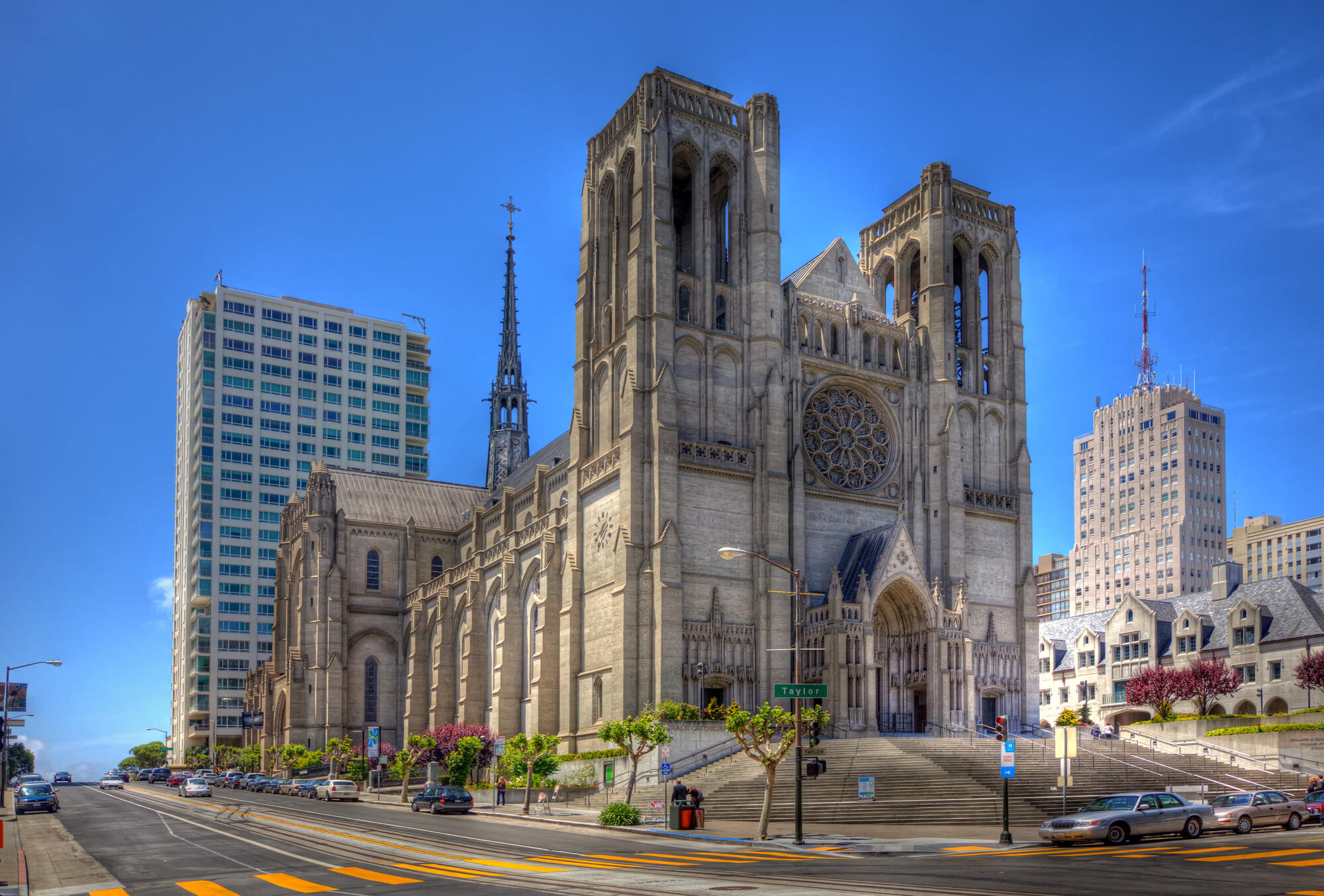 Grace Cathedral's twin bell towers, rose window and broad entrance steps beneath a blue sky.