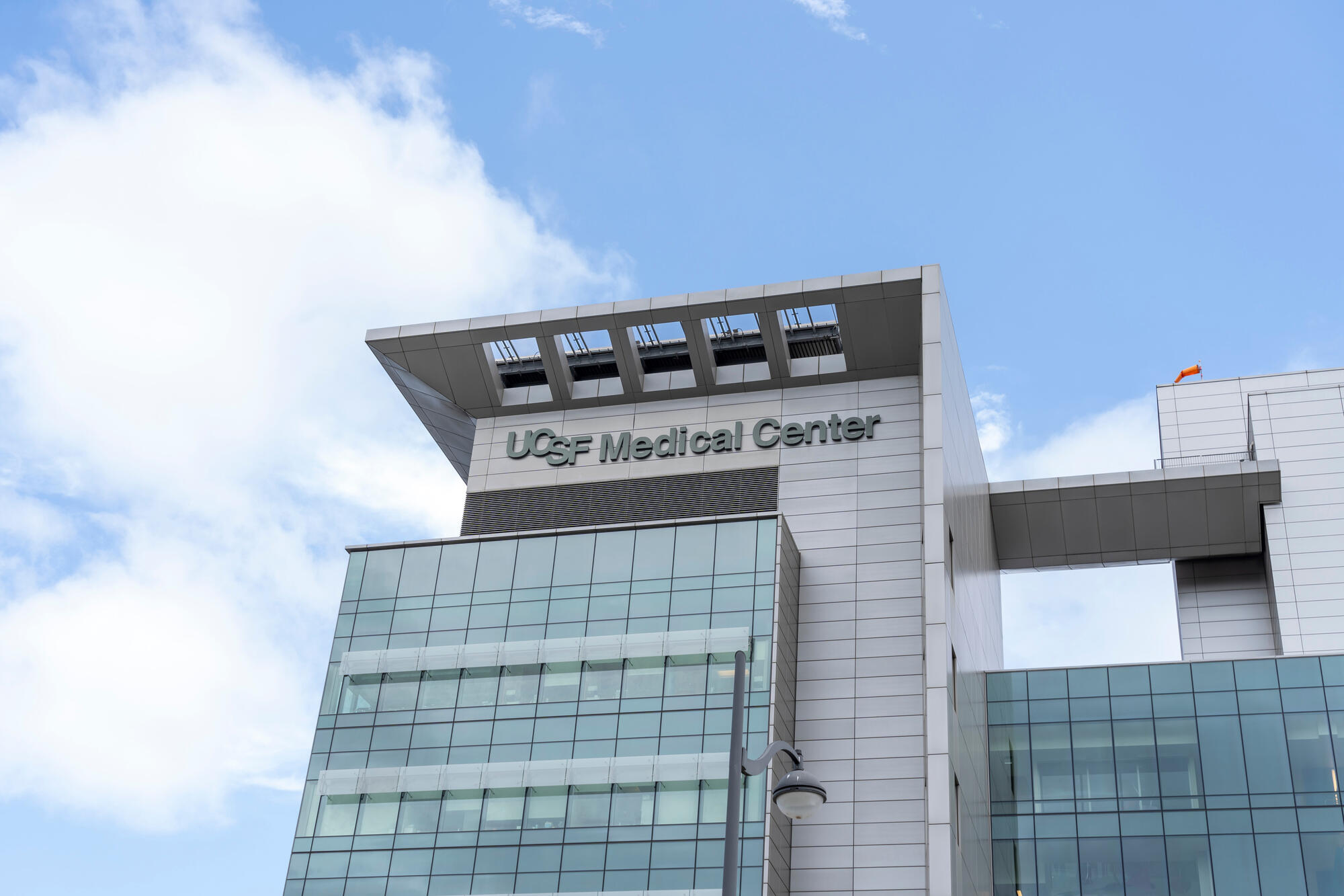 Glass panels, pale cladding and a broad projecting roof define the hospital building with its UCSF Medical Center sign.